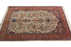 Load image into Gallery viewer, An ornate traditional Persian-style area rug with a complex floral and geometric pattern, featuring a cream center, deep red and navy borders, and cream fringe on the sides.