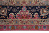 Load image into Gallery viewer, A close-up of a traditional patterned rug featuring a navy blue central field, pink and beige borders, and floral motifs in blue, gold, and rust.