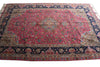 Load image into Gallery viewer, A traditional Persian-style area rug with a vibrant pink central field, intricate floral motifs, and a dark navy blue border with gold and beige accents.