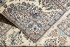 Load image into Gallery viewer, A close-up of a traditional Persian-style area rug with an intricate floral and vine pattern in blue, brown, and beige on a cream background.