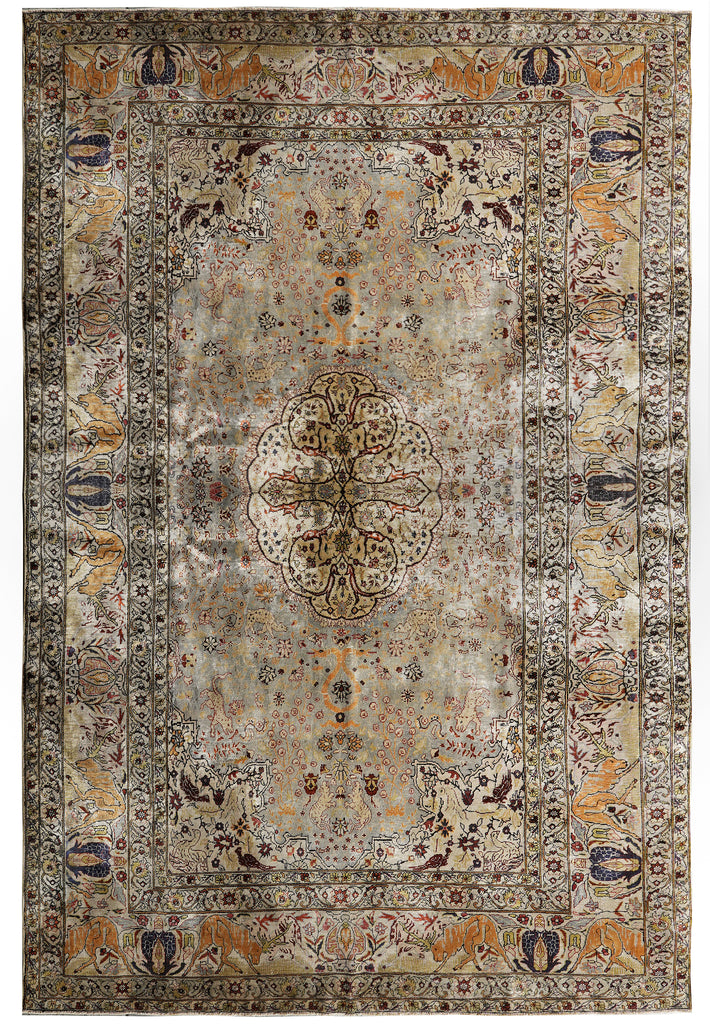 A rectangular traditional area rug with an intricate floral and medallion pattern, featuring a distressed vintage aesthetic in muted tones of beige, brown, gray, and gold.