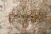 Load image into Gallery viewer, An antique Persian-style area rug with a faded central floral medallion, featuring a beige and dusty blue-gray base with rust red, brown, and navy accents.