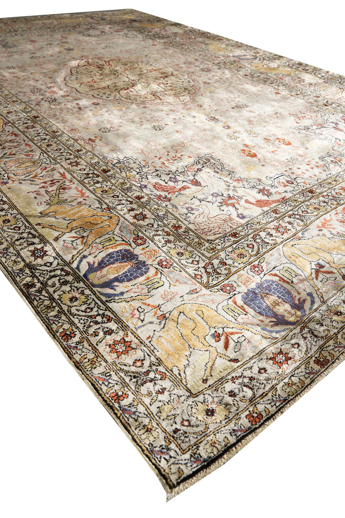 An antique-style oriental area rug with a distressed cream and beige field, featuring a detailed floral border and central medallion in muted tones of blue, rust red, and gold.