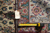 Load image into Gallery viewer, An ornate patterned area rug shown flat with a tape measure and price tag laid across it for scale and reference.
