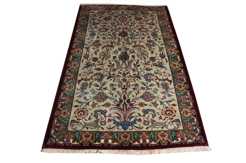 A rectangular traditional area rug with an intricate floral and vine pattern, featuring a cream center field, deep red borders, and multicolored accents, shown flat against a white background.