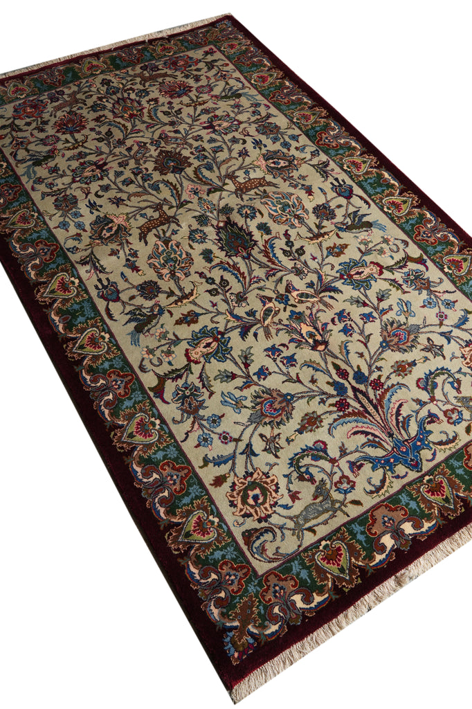 An ornate rectangular area rug with a cream center field, deep burgundy border, and intricate floral and vine motifs in blue, green, and rust red, shown on a plain white background.