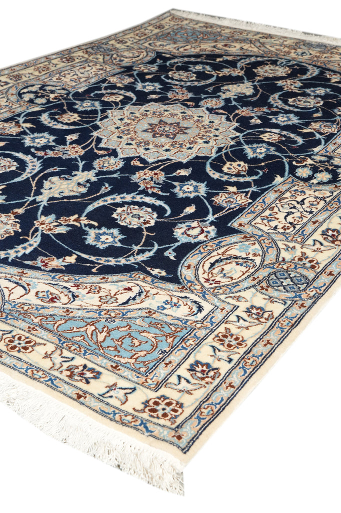 A traditional oriental area rug with a navy blue field, cream borders, and light blue accents, featuring intricate floral motifs and white fringe.