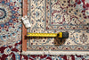 Load image into Gallery viewer, A close-up of a patterned area rug with a tape measure and a small handwritten tag placed on it to show dimensions.
