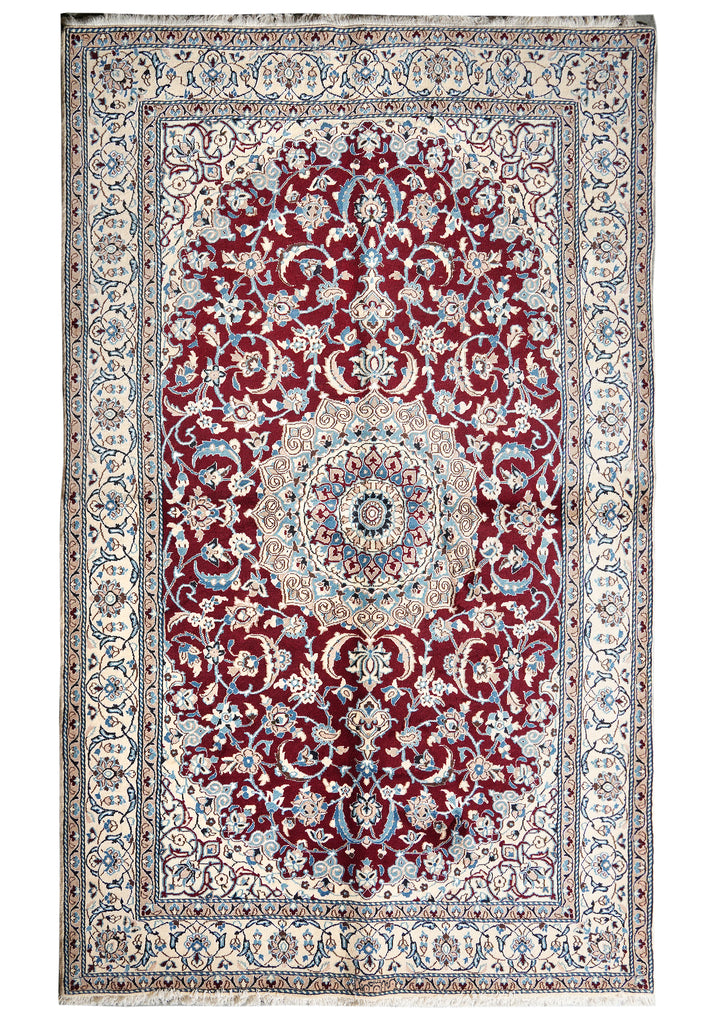 A traditional oriental area rug with a complex floral pattern, featuring a deep red central field, a cream and blue medallion, and a detailed multi-colored border.