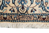 Load image into Gallery viewer, Close-up of a traditional patterned rug showing a cream base with blue, beige, and brown floral motifs and a fringed edge.