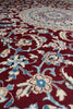 Load image into Gallery viewer, A close-up of a traditional patterned rug with a deep red background and cream, light blue, and beige floral motifs.
