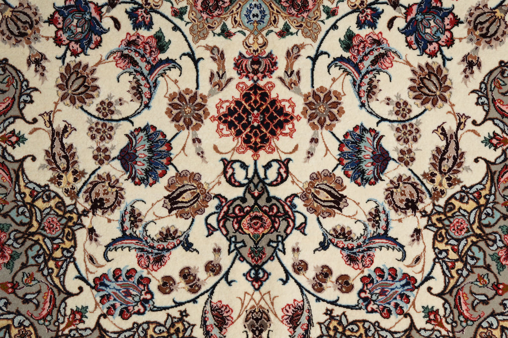 A close-up of an ornate traditional patterned rug with a cream background and intricate floral motifs in blue, red, brown, and gray.