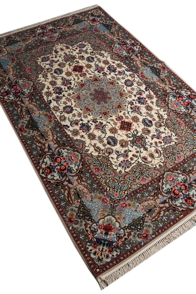An ornate rectangular area rug with a traditional Persian-style floral pattern, featuring a cream center, blue and red floral motifs, and a dark border with fringe on a white background.