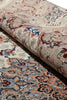 Load image into Gallery viewer, A close-up of a rolled area rug showing its detailed traditional floral and paisley pattern in beige, blue, red, and brown tones.