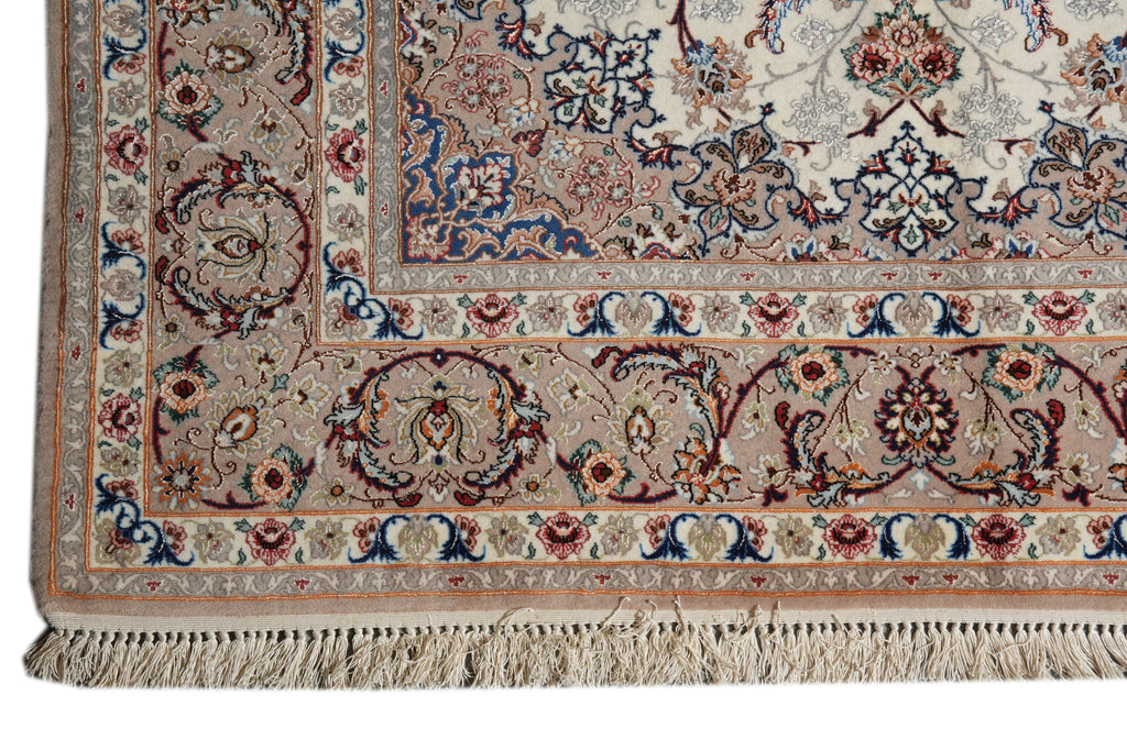 A close-up of an ornate patterned area rug corner showing detailed floral motifs, borders, and cream-colored fringe.