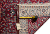 Load image into Gallery viewer, A close-up of a patterned area rug corner with a tape measure laid across it to show dimensions. The rug has a deep red field with cream, blue, and brown floral motifs and a decorative border.