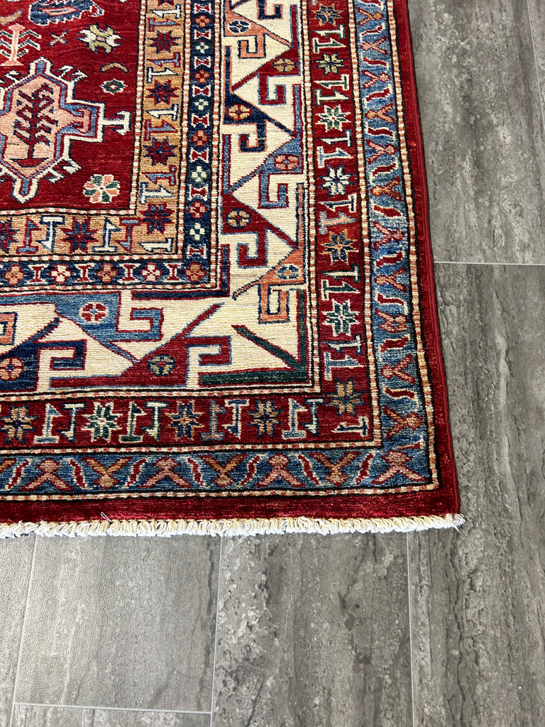 Image of a Child Playing on a Soft Kazak Rug: "Joyful child playing on a soft, plush 6x9 red Super Kazak wool rug, showcasing the rug's durability and family-friendly nature."