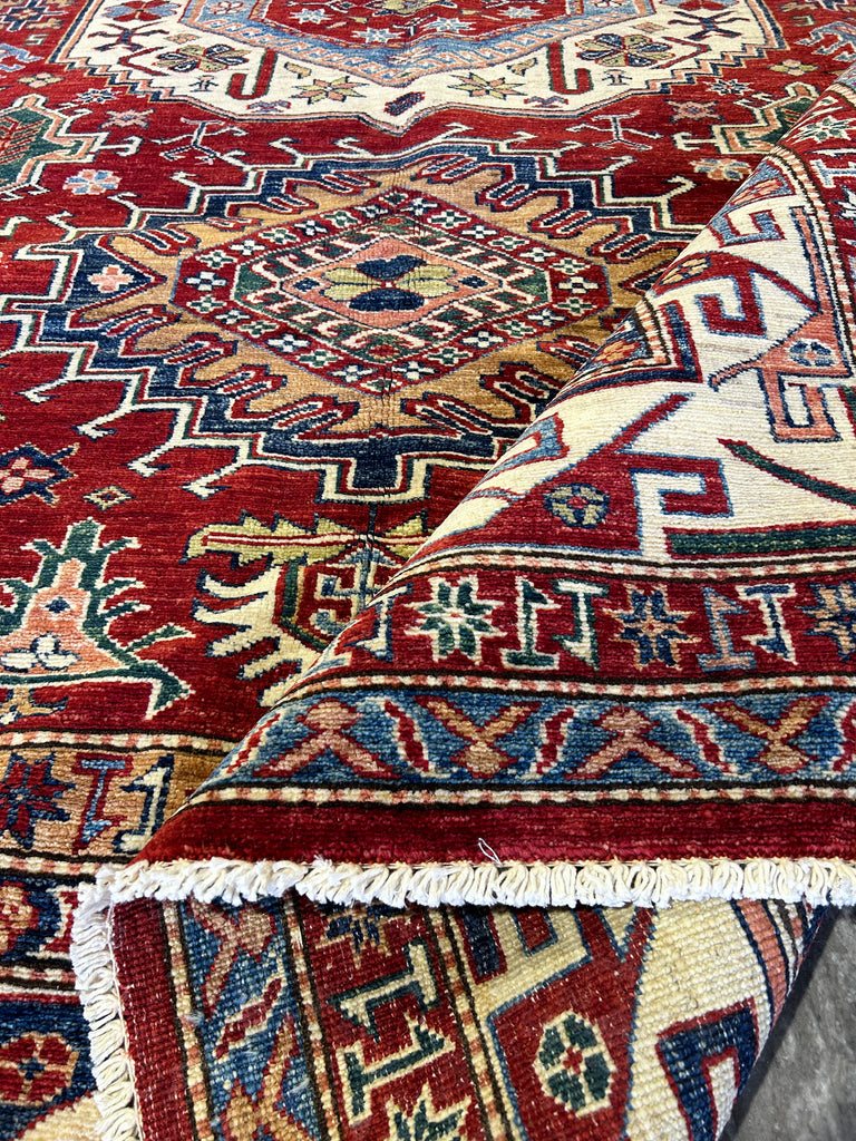 Close-up of Super Kazak Rug's Weave: "Detailed close-up of the intricate weave and vibrant red pattern of a handmade 6x9 Super Kazak wool rug, showcasing craftsmanship."