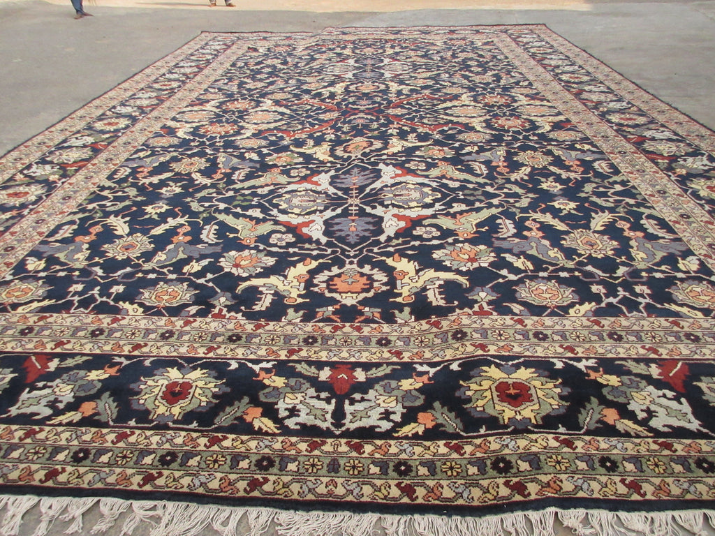 A large traditional oriental area rug with a dark navy blue field.