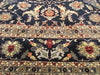 Load image into Gallery viewer, A close-up of an ornate traditional rug with a dark navy blue field, cream borders, and floral motifs in red, orange, green, and beige.