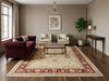 Load image into Gallery viewer, Living room with a burgundy sofa, coffee table, and decorative rug.