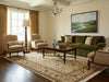 Load image into Gallery viewer, Living room with green sofa, beige armchairs, and a painting on the wall.