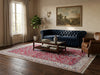 Load image into Gallery viewer, A styled living room featuring a deep navy blue tufted sofa placed on a large red and cream patterned oriental rug.