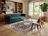 Load image into Gallery viewer, A styled living room featuring a teal blue-green tufted sofa as the main furniture piece, placed on a large patterned area rug over light wood floors. 