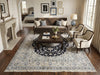 Load image into Gallery viewer, A large traditional-style area rug with an intricate blue, beige, and cream floral pattern is styled in a bright, elegant living room. 