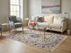 Load image into Gallery viewer, A styled living room featuring a large traditional Persian-style area rug in pink, blue, and beige tones on a light wood floor. The rug is styled under a cream-colored sofa with a glass-top coffee table, a blue-gray accent chair, and a window in the background.