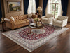 Load image into Gallery viewer, A large traditional Persian-style area rug with a red, beige, and blue pattern is displayed in a beautifully styled living room.