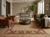 Load image into Gallery viewer, A large traditional oriental area rug in red, beige, and cream tones is styled in a warm, modern living room with a green sofa, brown leather armchairs, and a round wooden coffee table.