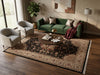 Load image into Gallery viewer, A large traditional-style area rug with a dark central field and ornate beige border, styled in a modern living room with a green sofa, two armchairs, a round coffee table, and wood flooring.