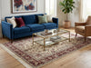 Load image into Gallery viewer, Living room with a blue sofa, glass coffee table, and patterned rug.