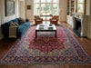 Load image into Gallery viewer, A large traditional oriental area rug with a red, blue, and beige floral pattern, styled in a classic living room.