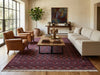 Load image into Gallery viewer, A styled living room featuring a large traditional Persian-style area rug in deep red and navy tones, with a wooden coffee table, a cream-colored sofa, two brown leather armchairs, and a potted fiddle-leaf fig plant.