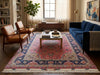 Load image into Gallery viewer, A large traditional Persian-style area rug with a red, blue, and beige floral pattern, styled in a cozy living room with a blue sofa, leather armchairs, and a glass-top coffee table.