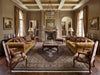 Load image into Gallery viewer, Luxurious living room with gold sofas, ornate chairs, and a fireplace.