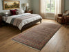 Load image into Gallery viewer, Bedroom with a large bed, decorative pillows, and a patterned rug on wooden flooring.